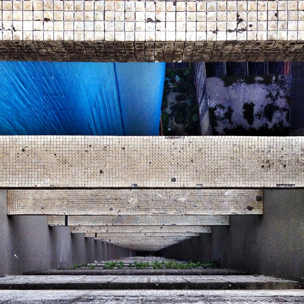 Estruturas de concreto e pastilhas do Edifício Copan vistas em perspectiva descendente, com linhas e planos geométricos. Mobgrafia e fotografia autoral de Eduardo Sardinha / Sardinha17. Local: Edifício Copan, Avenida Ipiranga, República, Centro de São Paulo, SP, Brasil. Temas: arquitetura modernista, Oscar Niemeyer, concreto, geometria, perspectiva, fachada, reflexos urbanos e cor azul predominante.