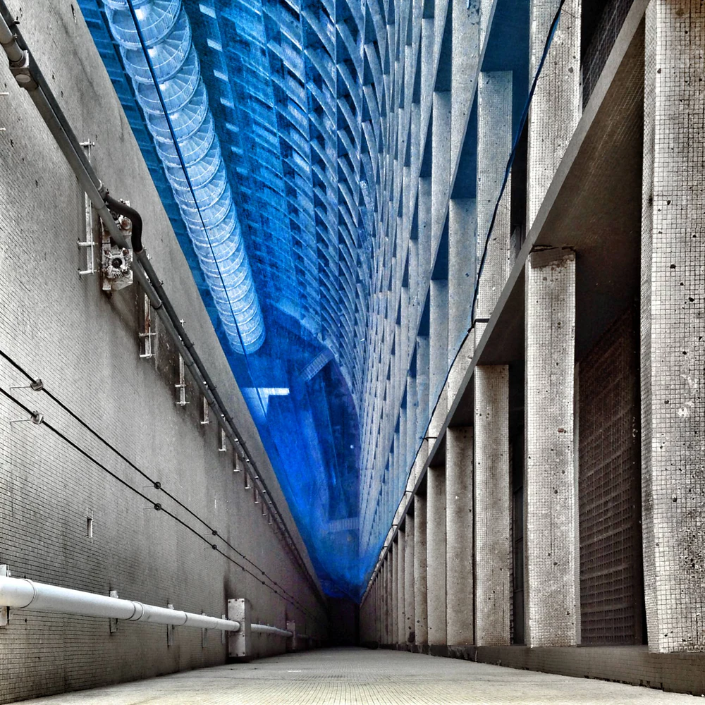 Vista arquitetônica vertical do Edifício Copan com planos de concreto, faixa azul e forte perspectiva.