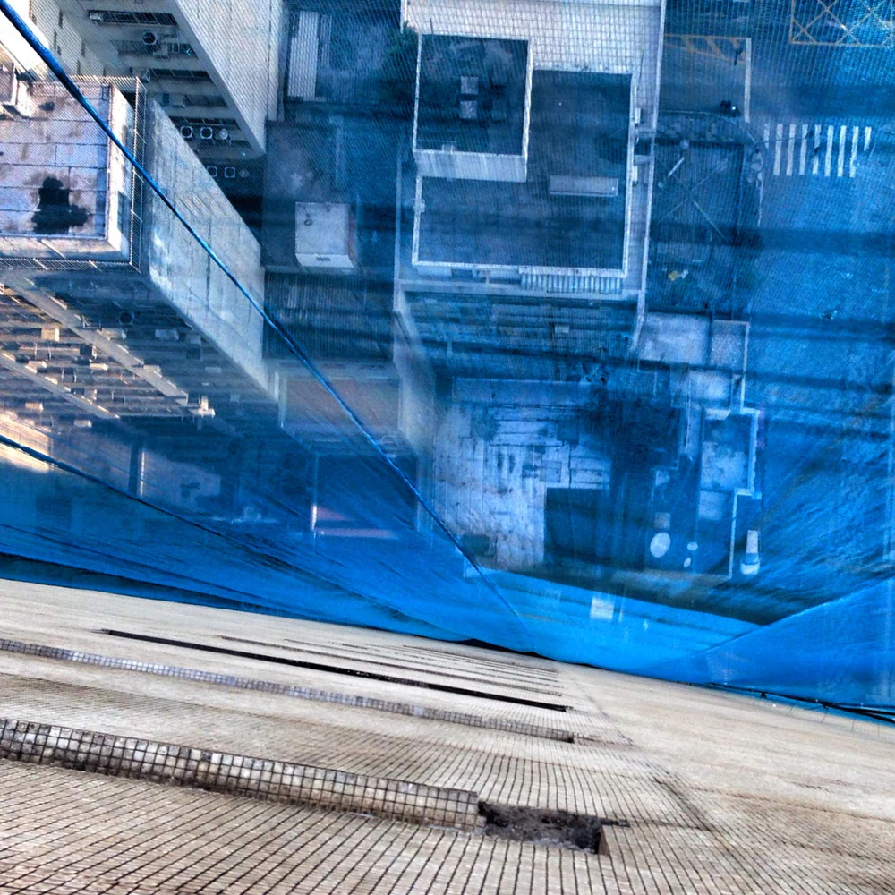 Composição de reflexos urbanos e arquitetura do Edifício Copan em predominância azul. Mobgrafia e fotografia autoral de Eduardo Sardinha / Sardinha17. Local: Edifício Copan, Avenida Ipiranga, República, Centro de São Paulo, SP, Brasil. Temas: arquitetura modernista, Oscar Niemeyer, concreto, geometria, perspectiva, fachada, reflexos urbanos e cor azul predominante.