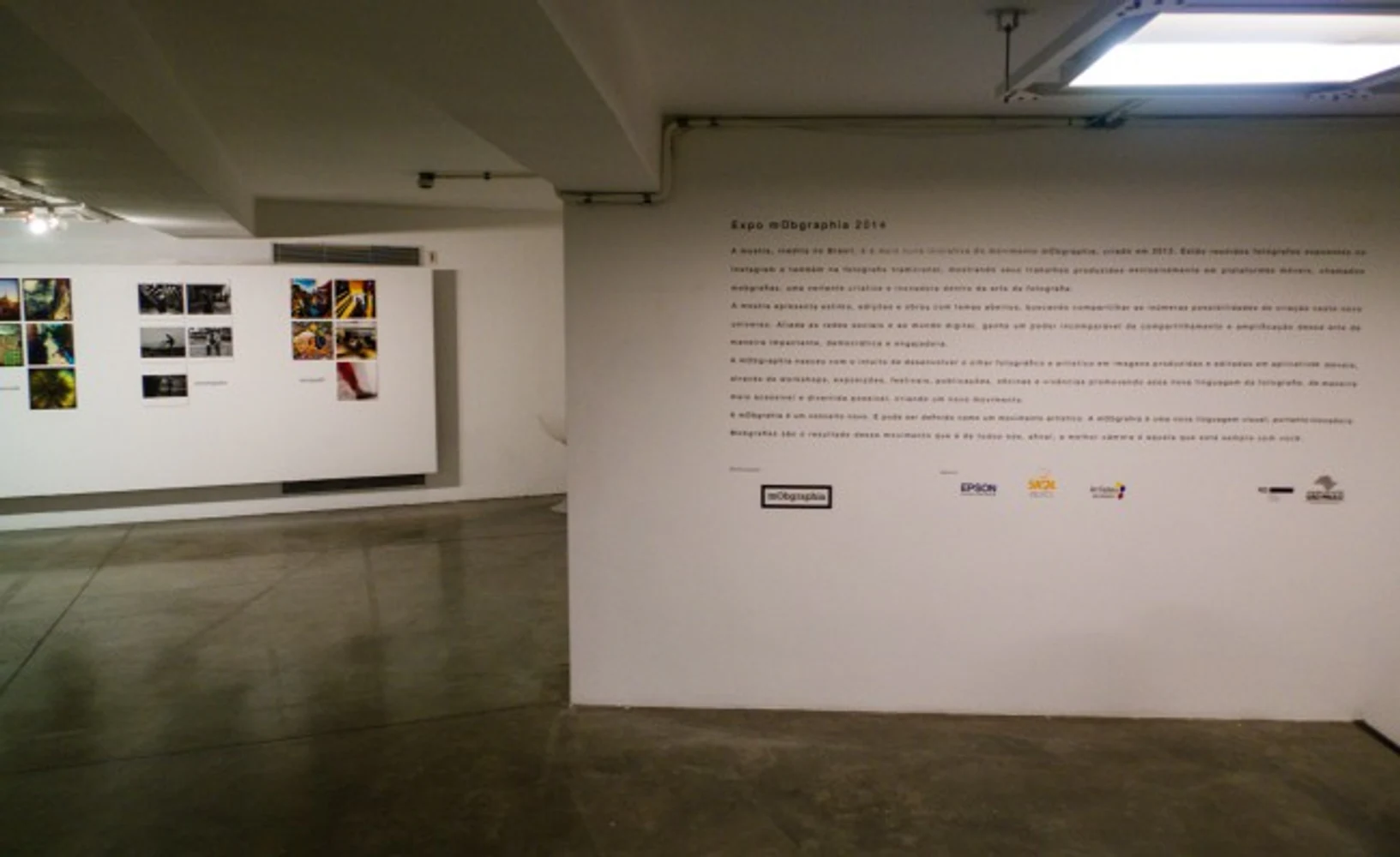 Entrada da Expo mObgraphia 2014 no MIS com texto curatorial, parede de fotografias e espaço de circulação.