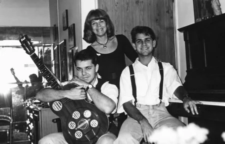 Retrato familiar preto e branco da Mississampa Blues Band com Marina Teixeira de Mello, Eduardo Sardinha e Rogério Mello entre violão e piano.