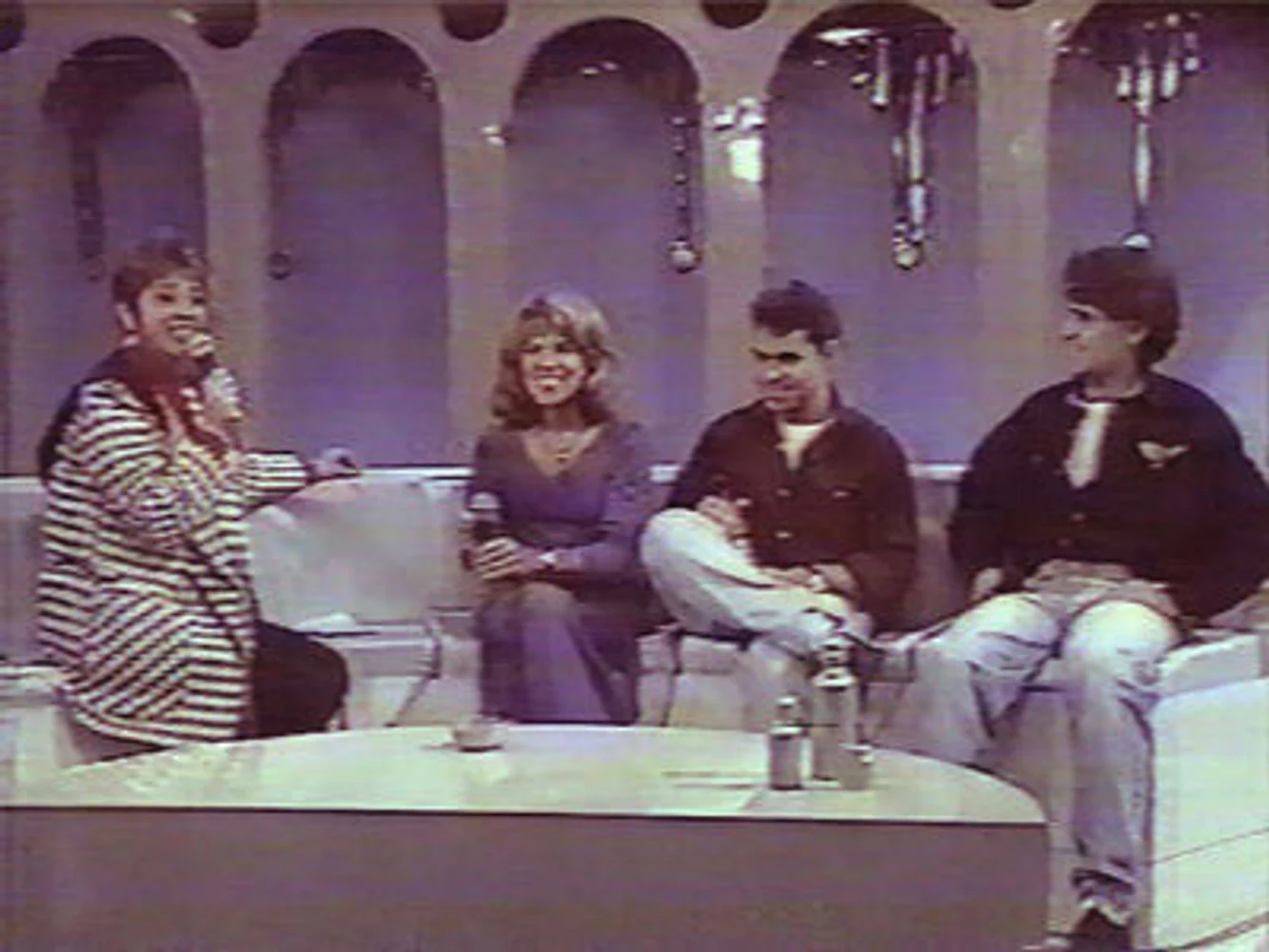Marina Teixeira de Mello, Eduardo Sardinha e Rogério Mello participam de entrevista da Mississampa Blues Band em estúdio de televisão. Elementos visíveis: mãe e filhos, integrantes da banda, apresentador, poltronas, mesa, cenário de TV, entrevista, comunicação e arquivo audiovisual. Fotografia e arquivo autoral de Eduardo Sardinha / Sardinha17.