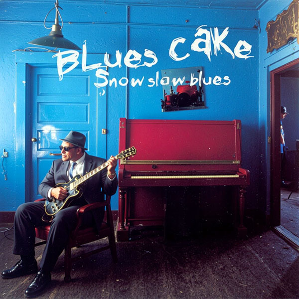 Arte de capa de Snow Slow Blues, do Bluescake, com músico de terno, chapéu e óculos escuros tocando guitarra junto a piano vertical. Elementos visíveis: guitarrista, cadeira, piano, porta, luminária, interior azul, magenta, tipografia e fotografia musical. Bluescake: Eduardo Sardinha e Luiz Carlos Big. Arquivo e direção visual: Eduardo Sardinha / Sardinha17.