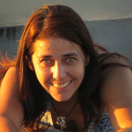 Retrato de Adriana Mello sorrindo sob luz dourada do sol